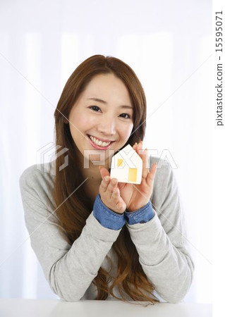 A young lady with a house model 15595071