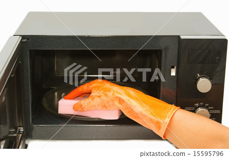 Hand with sponge cleaning microwave oven 15595796