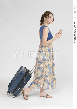 觀看智能手機的婦女，當拉扯運載袋子時 15601410