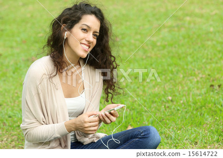 Foreign women listening to music at the park Foreign women listening to music at the park 15614722