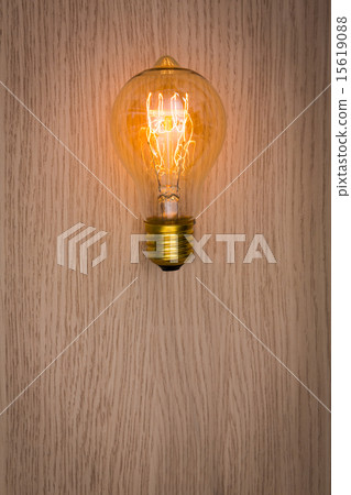 Glowing bulb on the wooden table 15619088