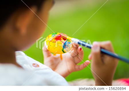 Child painting easter egg with paintbrush Child painting easter egg with paintbrush 15620894