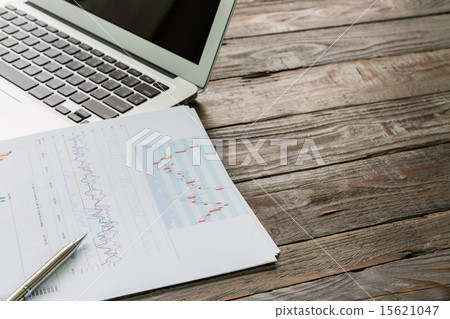 Financial charts on the table with laptop 15621047