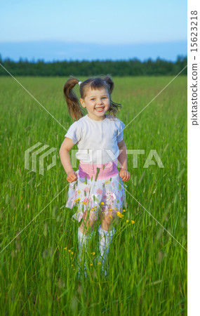 Happy child jumps on green grass in field Happy child jumps on green grass in field 15623218