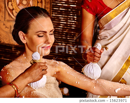 Woman having massage with pouch of rice. 15623971
