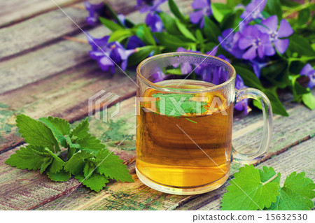 A cup of melissa herbal tea on a wooden table 15632530