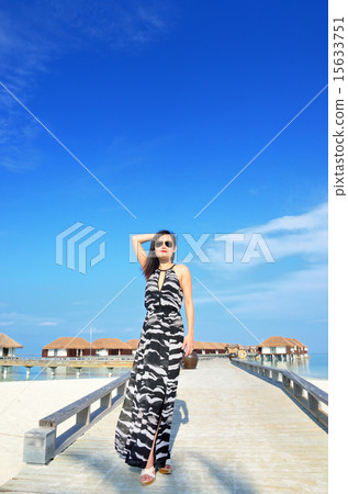 A blue sky and a beach and a young lady 15633751