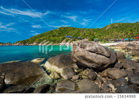 rocks on the beach with blue sky and mountain 15634998