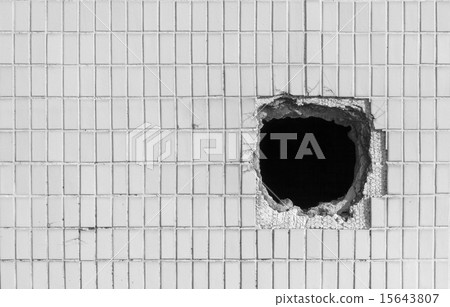 Hole on the old white wall 15643807