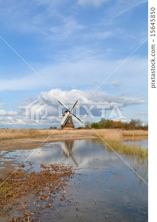 Dutch windmill over blue sky and river 15645850