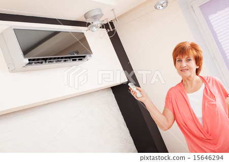 Woman holding a remote control air conditioner Woman holding a remote control air conditioner 15646294