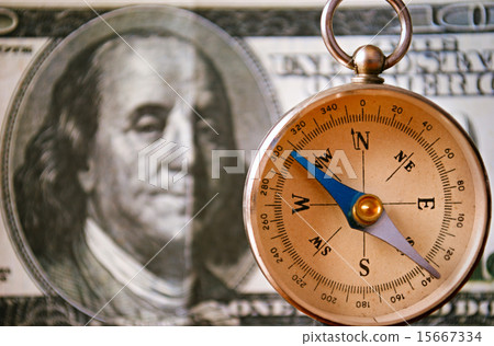 Vintage Compass Standing In Front of 100 USD Bill 15667334