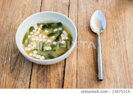 bowl of soup with tofu cheese and spoon on table bowl of soup with tofu cheese and spoon on table 15675314