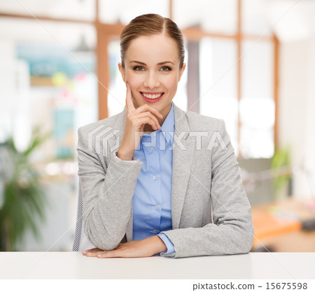 smiling businesswoman sitting at table smiling businesswoman sitting at table 15675598