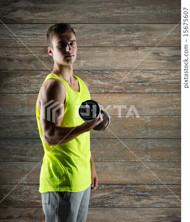 young man with dumbbell flexing biceps 15675607