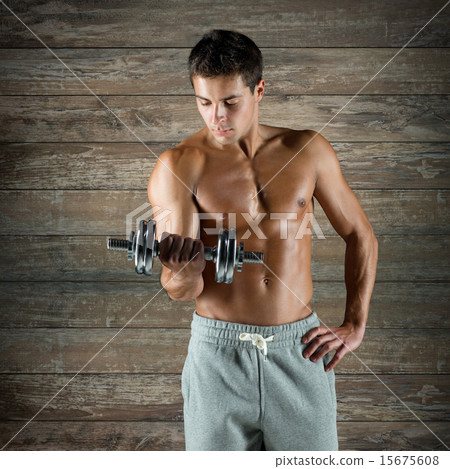young man with dumbbell flexing biceps young man with dumbbell flexing biceps 15675608