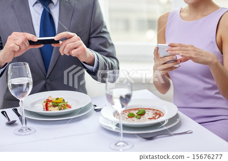 close up of couple with smartphones at restaurant close up of couple with smartphones at restaurant 15676277
