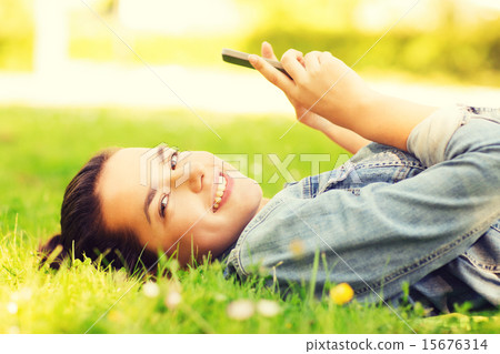 smiling young girl lying on grass 15676314