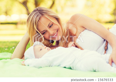 happy mother lying with little baby on blanket 15676533