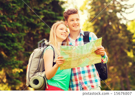 smiling couple with map and backpack in forest smiling couple with map and backpack in forest 15676807