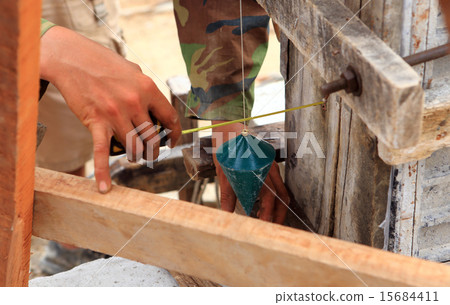 labor man using a plumb bob for check . 15684411