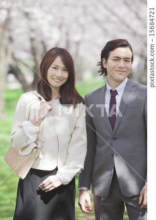 A couple standing on a row of cherry blossoms 15684721