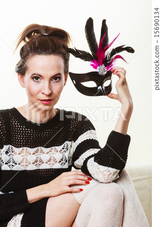 woman with carnival mask sitting on sofa 15690134