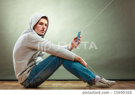 Stock Photo: Hooded man with headphones listening music