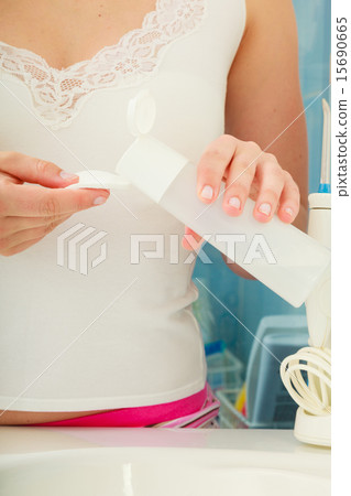 woman holding cotton swab and makeup remover in hands woman holding cotton swab and makeup remover in hands 15690665
