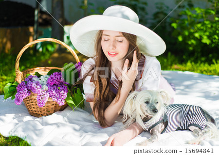 Beautiful girl outdoors with a dog and a lilac 15694841