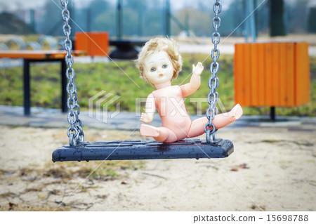Old abandoned doll on a swing 15698788
