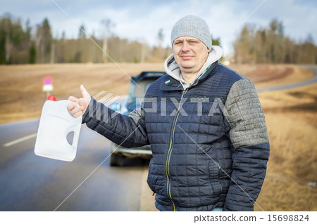 Man with empty can waiting for help near car on th Man with empty can waiting for help near car on th 15698824