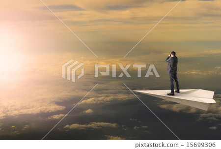 business man standing and spying binocular on papet plane agains 15699306