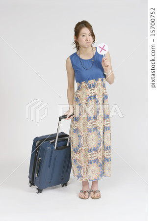 A woman who puts a plate of a pair at the side of a carry bag 15700752