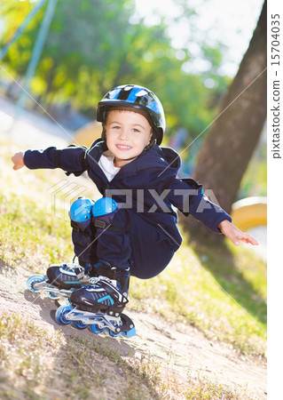 Cute boy rollerblading near the playground Cute boy rollerblading near the playground 15704035