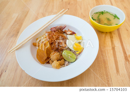 Asian dry noodle with garnish on the wooden background Asian dry noodle with garnish on the wooden background 15704103