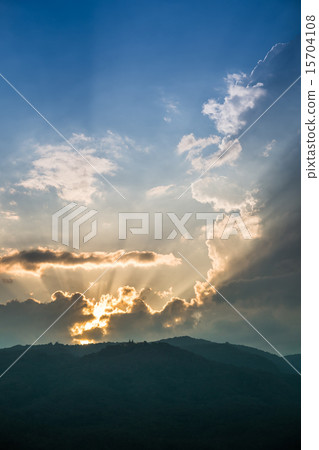 Sunset behind mountain with beautiful sunbeam through the cloud 15704108