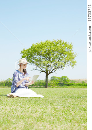 A woman using a tablet in the open space A woman using a tablet in the open space 15733741
