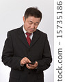 A businessman operating a smartphone 15735186