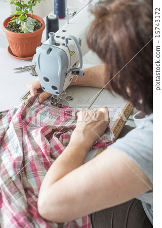 Women sew on sewing machine 15743172