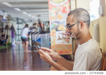 Asian man using smartphone 15744898