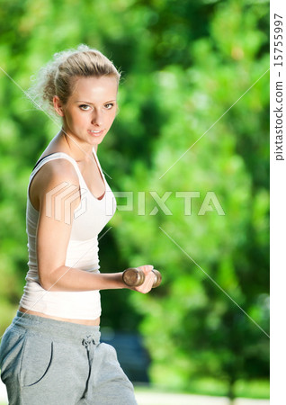 Woman doing dumbbell exercise outdoor 15755997