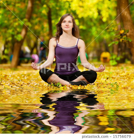 Woman doing yoga exercises in the autumn park 15756079