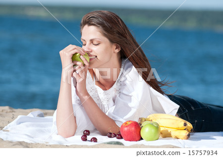 Woman on beach eating fruits Woman on beach eating fruits 15757934