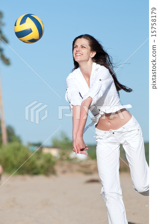 Woman playing volleyball on beach 15758179