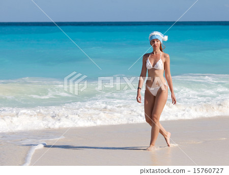 young woman in the New Year's cap walks on a beach young woman in the New Year's cap walks on a beach 15760727