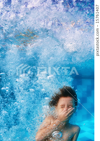 Smiling child swimming underwater in pool Smiling child swimming underwater in pool 15761407