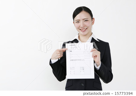A smiling woman pointing to the entry sheet 15773394