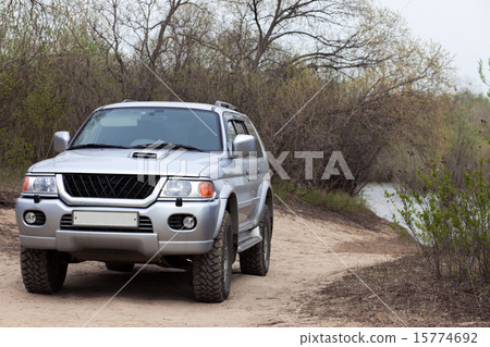 4x4 SUV on a road near a pond 15774692