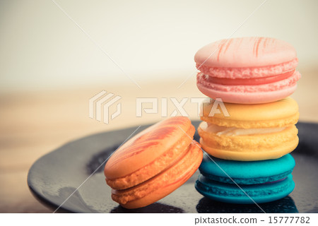 Colorful macaron in black dish on wooden floor Colorful macaron in black dish on wooden floor 15777782